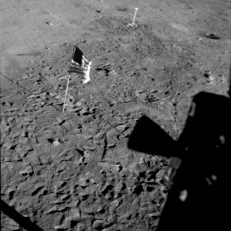 This July 21, 1969 photo made available by NASA shows a U. S.  flag planted at Tranquility Base on the surface of the moon, and a silhouette of a thruster at right, seen from a window in the Lunar Module. NASA via AP