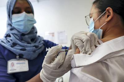 DUBAI, UNITED ARAB EMIRATES , September 16 – 2020 :- Resy Hussain, Nurse giving the Flu vaccine shot to Flora Mae (patient) at the Prime Hospital in Dubai.  (Pawan Singh / The National) For News/Online. Story by Nick Webster