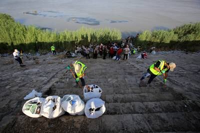Iraqi volunteers remove plastic waste from the banks of the Tigris river in central Baghdad.  EPA 