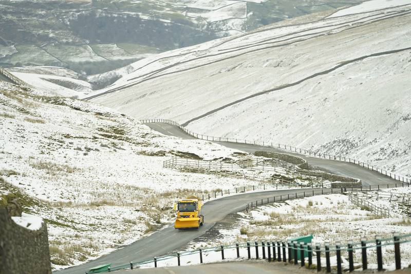 A snow plough and gritting vehicle driving along the snow-lined Buttertubs Pass near Hawes in the Yorkshire Dales on Thursday. After a warm start to the year the UK experienced snowfall across parts of Scotland and the north of England. PA