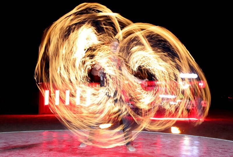 The venue features live performers, including singers and fire dancers