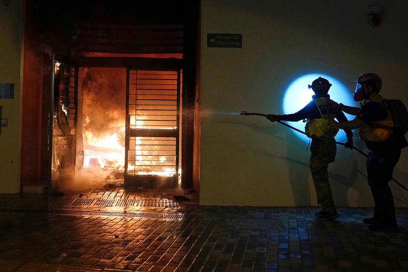 First aid volunteers work to extinguish a fire set by local residents after the Hong Kong government announced it would requisition the unoccupied housing project to house quarantined patients of the new viral coronavirus illness.  AP