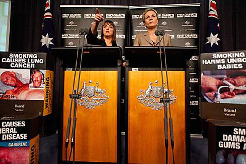 Australian Attorney General Nicola Roxon left, and the Tanya Plibersek, the health minister, speak after Australia’s highest court ruled it was legal for the government to make tobacco companies package cigarettes without prominent branding.