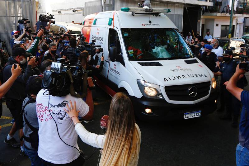 The ambulance carrying Diego Maradona is surrounded by well wishers as he leaves hospital. Getty