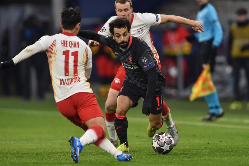 Liverpool's Egyptian midfielder Mohamed Salah (C) and Leipzig's Korean forward Hwang Hee-chan (L) vie for the ball during the UEFA Champions League round of 16 first leg football match between RB Leipzig and FC Liverpool at the Puskas Arena in Budapest on February 16, 2021. / AFP / Attila KISBENEDEK
