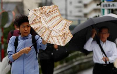 Passersby using umbrellas struggle against a heavy rain and wind wind caused by Typhoon Faxai in Tokyo, Japan September 9, 2019. REUTERS/Issei Kato