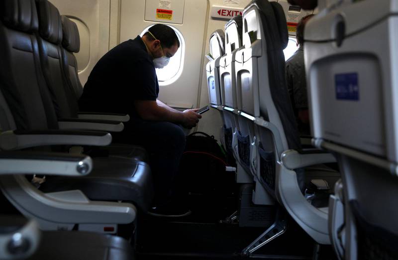 HOUSTON, TEXAS - MAY 11: A passenger looks at his phone while waiting aboard a United Airlines plane before taking off from George Bush Intercontinental Airport on May 11, 2020 in Houston, Texas. Air travel is down as estimated 94 percent due to the coronavirus (COVID-19) pandemic and major U.S. airlines are taking a major financial hit with losses of $350 million to $400 million a day and nearly half of major carriers airplanes are sitting idle.   Justin Sullivan/Getty Images/AFP
== FOR NEWSPAPERS, INTERNET, TELCOS & TELEVISION USE ONLY ==
