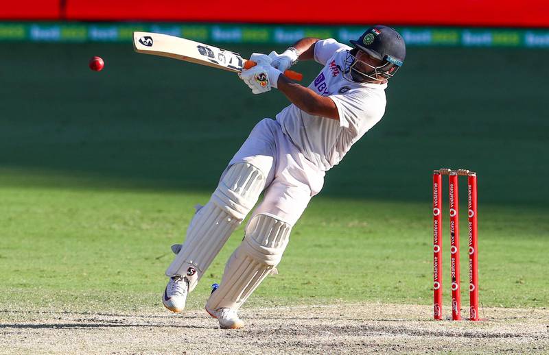 Rishabh Pant falls as he hits the ball for four runs . AP
