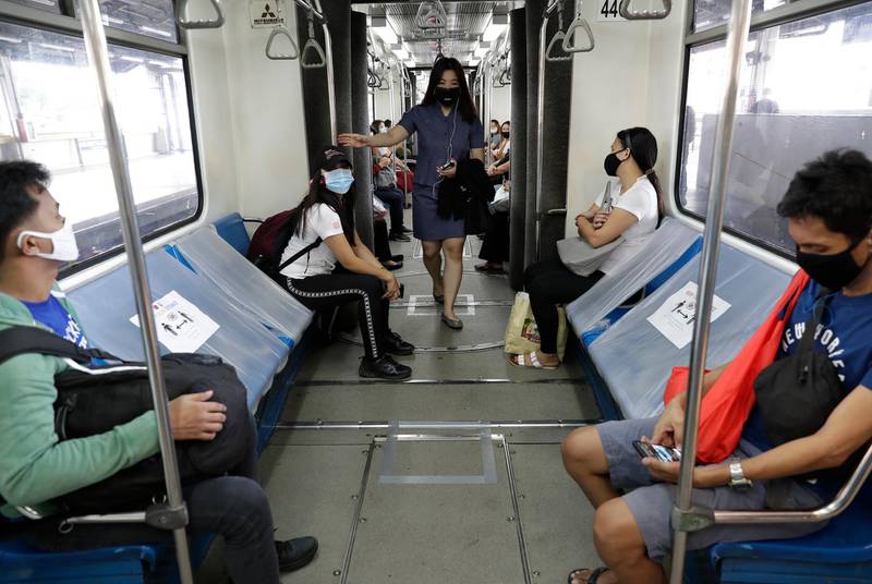 People board a train with seats arranged for social distancing. AP Photo