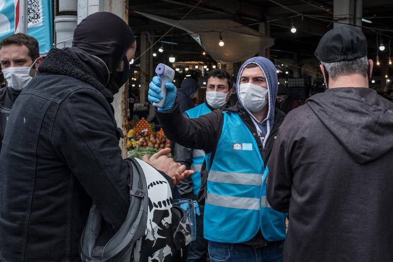 Besiktas municipality police and employees distribute masks, check ID's and take the temperature of people arriving at the entrance of the Besiktas market in Istanbul, Turkey. Getty Images