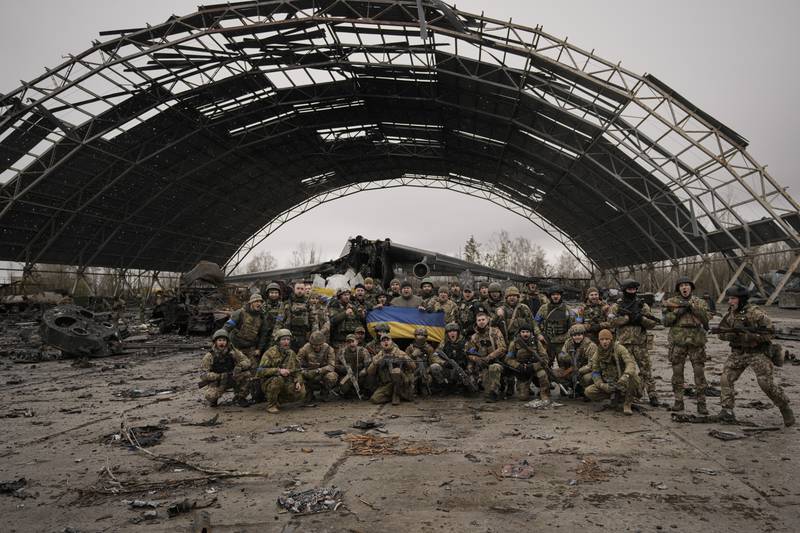 Ukrainian soldiers shout patriotic slogans with the Antonov An-225 in the background. AP