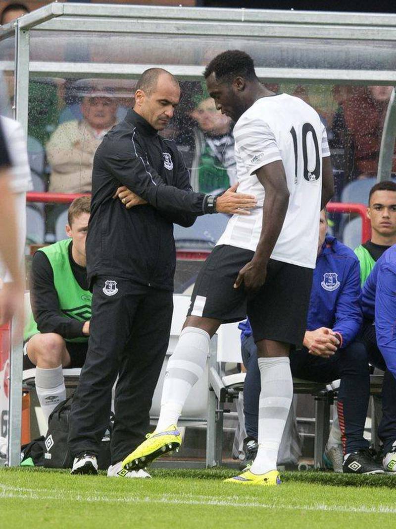 Romelu Lukaku goes off injured and shows his injury to manager Roberto Martinez . Jeff Holmes / Getty Images