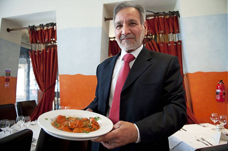 Ahmed Aslam Ali, at his Shish Mahal restaurant in Glasgow, shows a plate of chicken tikka masala. AFP