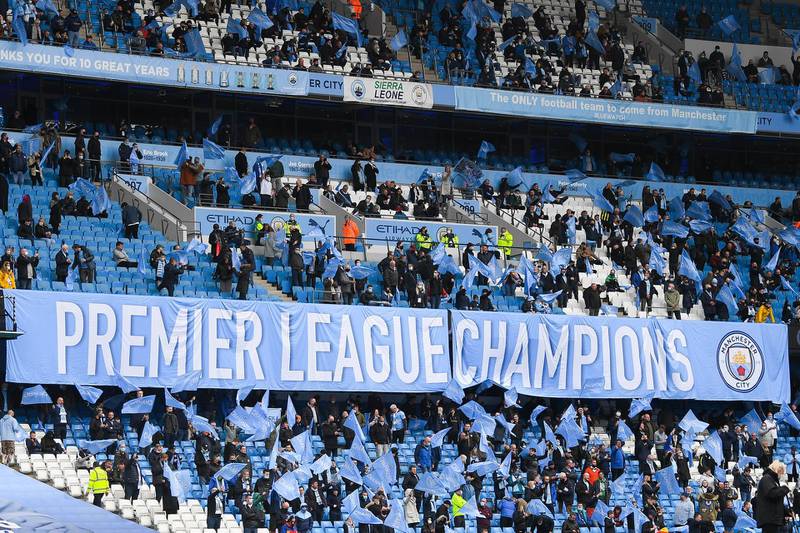 Manchester City fans show their support by holding up a Premier League champions banner at the Etihad Stadium. Getty