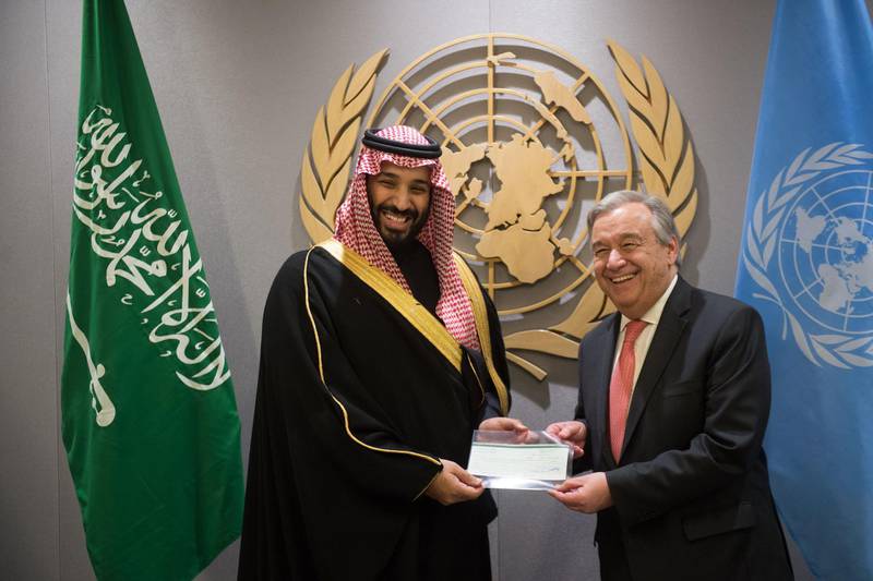Prince Mohammed bin Salman Al Saud (L), Crown Prince, Kingdom of Saudi Arabia, presents a check for $930 billion to  United Nations Secretary-General Antonio Guterres (R) following the signing of the Voluntary Financial Contribution Memorandum between the Kingdom of Saudi Arabia and the United Nations to the 2018 Yemen Humanitarian Response Plan at the United Nations on March 27, 2018 in New York. / AFP PHOTO / Bryan R. Smith