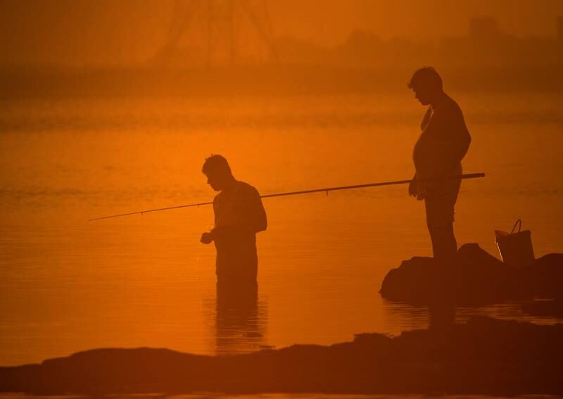 Anglers fish in the fog at Yas Iron Bridge in Abu Dhabi. Victor Besa / The National