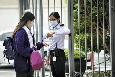 A student in protective face mask gets her temperature checked at the entrance of Al-Mizhar American Academy as the government re-opens schools after months in the wake of Covid-19 pandemic in Dubai, UAE, Sunday, Aug. 30, 2020. (Photos by Shruti Jain - The National)
