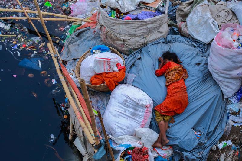 Amdad Hossain - Sleep FatigueA woman sleeps on a dirty riverbank in Dhaka, Bangladesh.