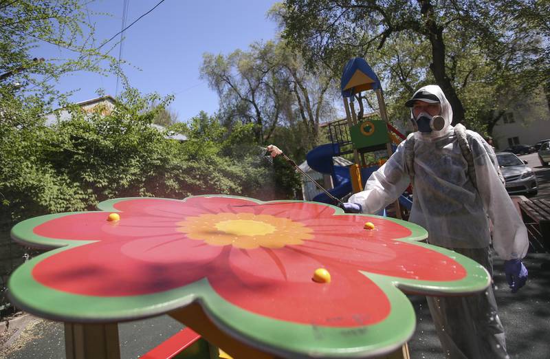 A specialist wearing protective gear sprays disinfectant while sanitising a playground to prevent the spread of the coronavirus disease in Almaty, Kazakhstan. Reuters