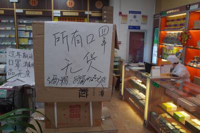 A sign reads that face masks, alcohol and disinfectant water are sold out at a drug store in Beijing. EPA