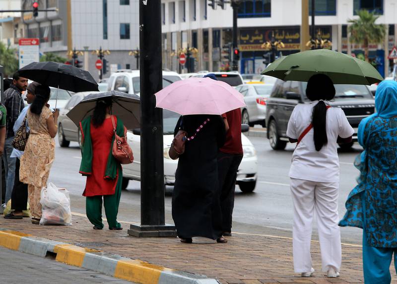 Residents reach for their umbrellas in Al Ain. Photo: The National