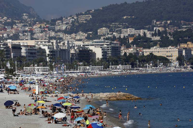  People enjoy the sun on a beach of the Promenade des Anglais in Nice, southern France. EPA
