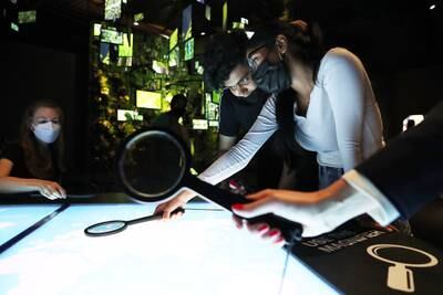 Visitors use magnifiers to check countries' eco details at the Germany pavilion.