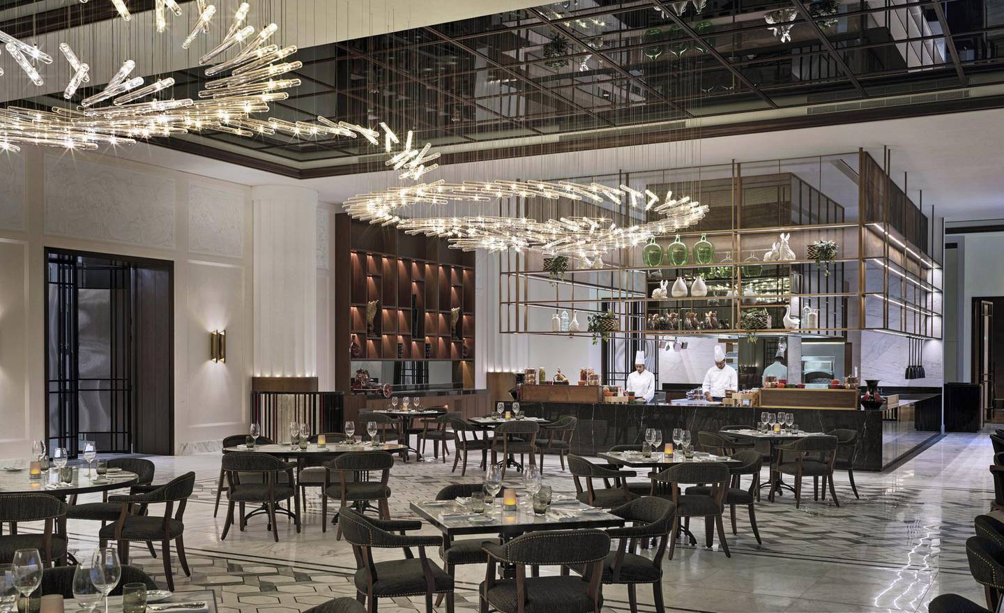 The art deco-inspired interiors of Brasserie Boulud feature a mirrored ceiling and chandeliers