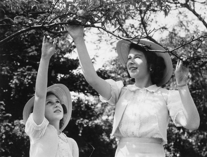 Princess Elizabeth and Princess Margaret play with their pet chameleon at Windsor Castle in 1941. Getty