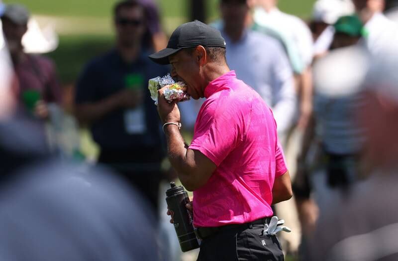 Woods eats a sandwich on the 8th fairway. Reuters