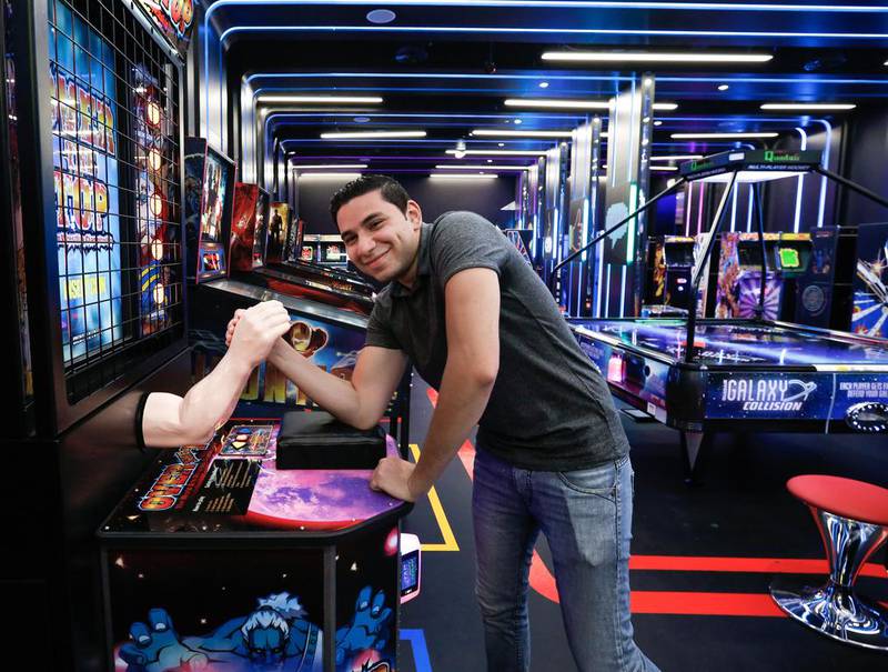 A visitor tries his hand at Over The Top, an old school arm-wrestling arcade game at Hub Zero in Dubai’s City Walk. Victor Besa for The National