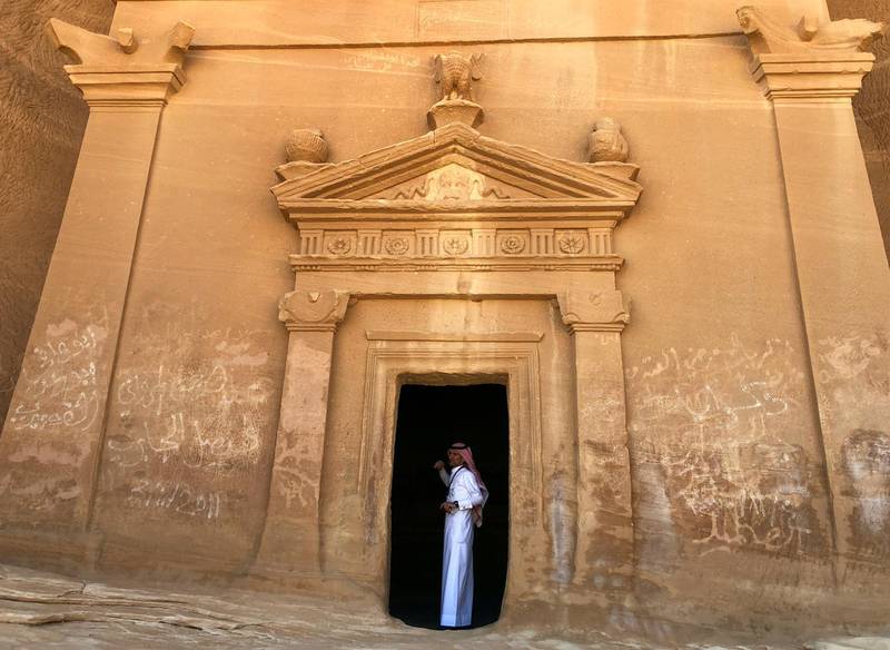 A Saudi tour guide stands inside a tomb at the Madain Saleh antiquities site in AlUla. Reuters