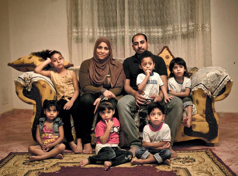 In this May 31, 2017 photo, Egyptian father Youssef Shaman Gumaa, center right, and his wife Sarah Hassan Shehata, pose for a photograph with their 4 year-old quintuplets and their 7 year-old sister, top left, at their home during the holy month of Ramadan, in Madinet el-Salam on the outskirts of Cairo, Egypt. Census workers going door to door in Egypt‚Äôs teeming neighborhoods and crowded towns are discovering a new country _ of more than 20 million people born in the last decade alone. (AP Photo/Nariman El-Mofty)