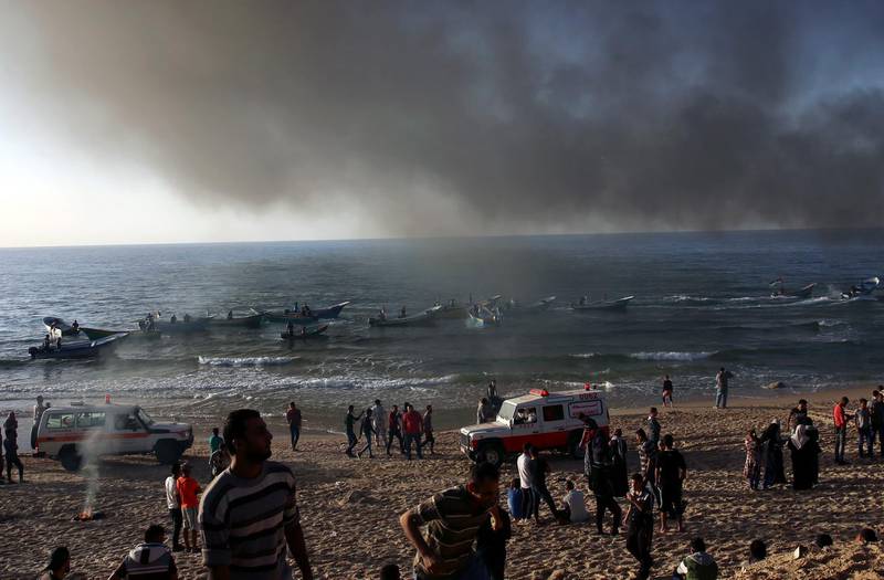 Protesters watch fishing boats flee during a protest on the beach near Beit Lahiya, northern Gaza Strip. AP Photo
