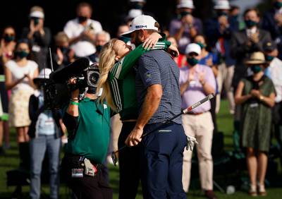 Dustin Johnson celebrates with his partner Paulina Gretzky on the 18th green. Reuters