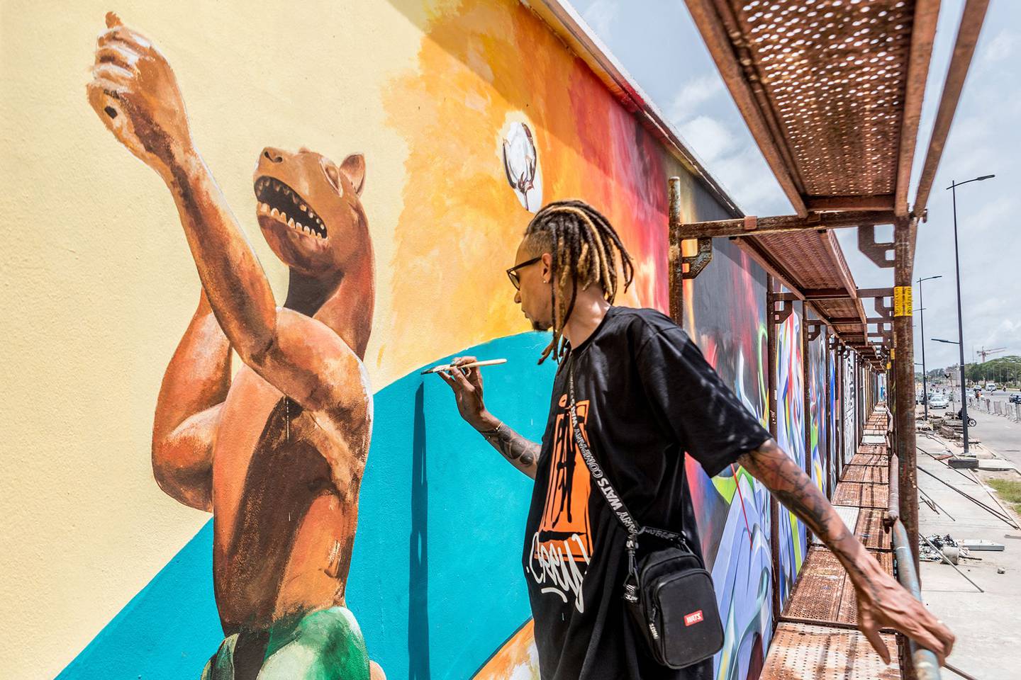 Brazilian artist Edgar Bernado Dos Santos, also known as Ed-mun, paints with a brush at the Effet Graff festival in Benin. AFP