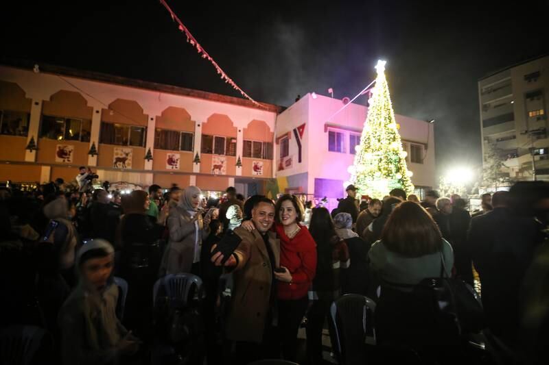 Residents get a selfie with the brightly illuminated Christmas tree in Gaza city.