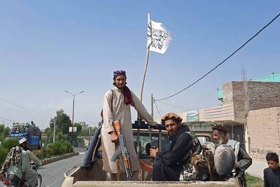 Taliban fighters drive through the streets of Laghman province.