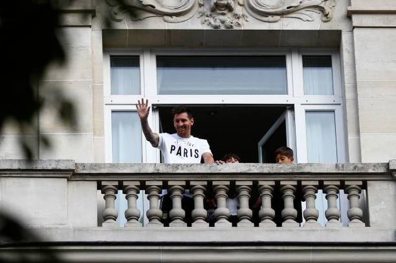 Argentina football player Lionel Messi waves at fans from a balcony of the Royal Monceau hotel in Paris.