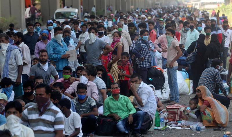 Migrant workers wait to board buses for their onward journey by train to their home states, at Dharavi, one of Asia's largest slums, in Mumbai, India, Friday, May 22, 2020. India's lockdown was imposed on March 25 and has been extended several times. On May 4, India eased lockdown rules and allowed migrant workers to travel back to their homes, a decision that has resulted in millions of people being on the move for the last two weeks. (AP Photo/Rafiq Maqbool)