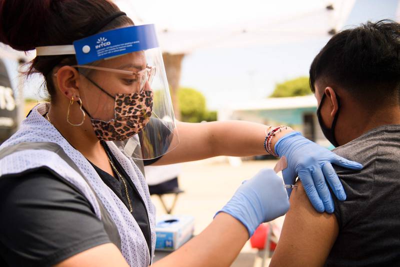 A 17-year-old receives a first dose of the Pfizer Covid-19 vaccine at a mobile vaccination clinic during a back to school event offering school supplies, Covid-19 vaccinations, face masks, and other resources for children and their families at the Weingart East Los Angeles YMCA in Los Angeles, California on August 7, 2021. AFP