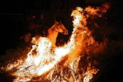 Two women ride a horse through flames during the annual 'Luminarias' celebration on the eve of Saint Anthony's day in the village of San Bartolome de Pinares, northwest of Madrid. Juan Medina / Reuters