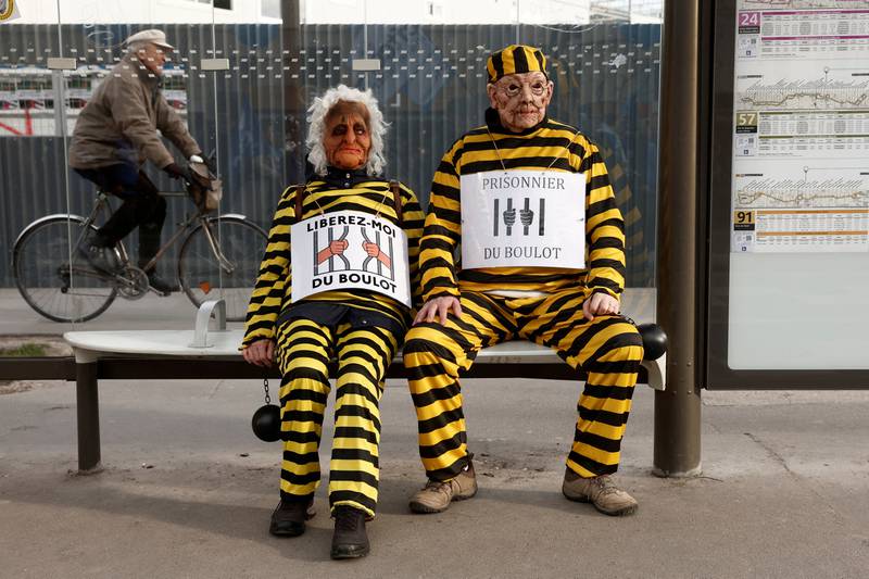 Protesters in Paris for a demonstration against the French government's pension reform plan. The slogans read 'Free me from work' and 'Prisoner of work'. Reuters