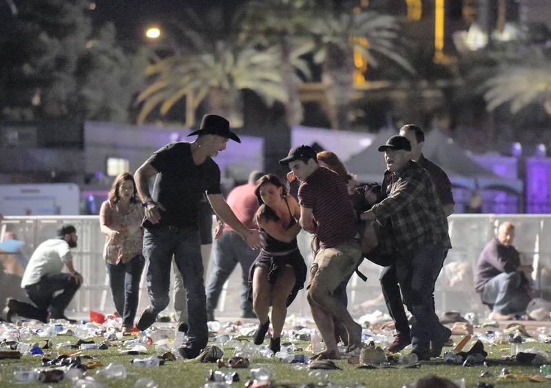 LAS VEGAS, NV - OCTOBER 01: (EDITORS NOTE: Image contains graphic content.) People carry a peson at the Route 91 Harvest country music festival after apparent gun fire was heard on October 1, 2017 in Las Vegas, Nevada. There are reports of an active shooter around the Mandalay Bay Resort and Casino.  (Photo by David Becker/Getty Images)