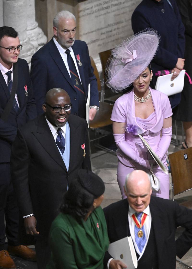 Edward Enninful porte un gilet bleu avec son costume, tandis que Katy Perry porte du tout rose.  PA