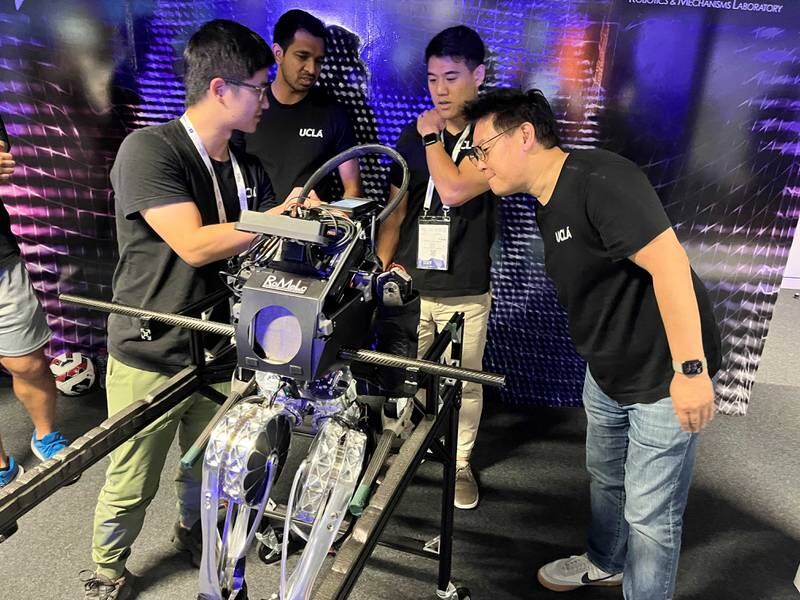 Dennis Hong, profesor inżynierii mechanicznej i lotniczej na Uniwersytecie Kalifornijskim w Los Angeles oraz dyrektor RoMeLa, po prawej, ze swoim zespołem inżynierów i robotem Artemis w GITEX w Dubaju.  Nicka Webstera/The National