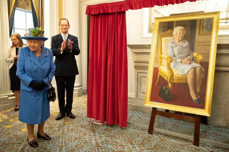 Queen Elizabeth looks at a new painting by BP Portrait Award 2017 winner, Benjamin Sullivan. The portrait was commissioned to celebrate 100 years of the RAF Club, in 2018. Getty Images