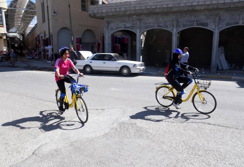 Cyclists ride to join fellow competitors and take part in the first all-female Mosul cycle race. EPA
