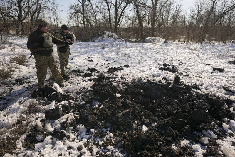 Ukrainian soldiers at the site where a rocket landed close to their positions during the night on a front line near Popasna, eastern Ukraine. AP
