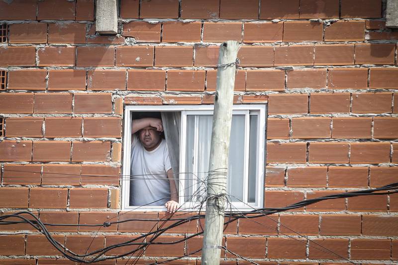 epa08709370 A man looks through the window of his house in Buenos Aires, Argentina, 30 September 2020. Argentina expected to release the percentage of the population below the poverty line as of the first half of the year. In December 2019 it was 35.5 percent and is expected to have increased due to the effects of the quarantine against the coronavirus decreed in March, still in force.  EPA/Juan Ignacio Roncoroni